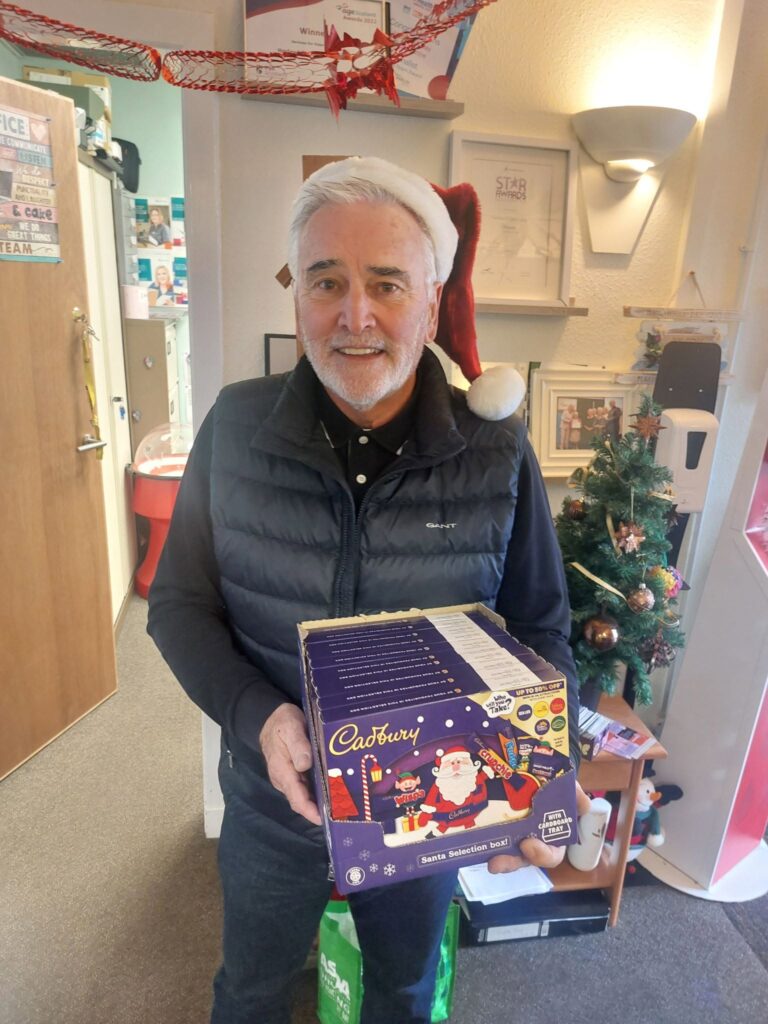 Tom Knight of T.K.S. Plumbing donates Christmas selection boxes for every Harlawhill Day Care Centre member.